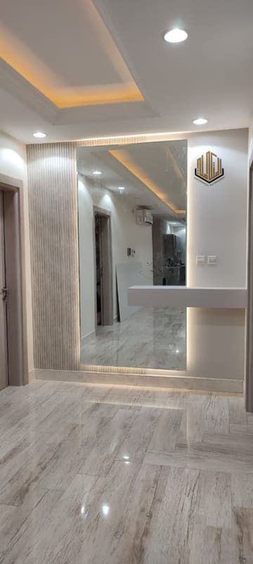 مدخل بمرآة طويلة ورف عائم وأرضية رخام