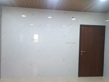 جدار مكسو بألواح بديل الرخام الأبيض وباب خشبي بني